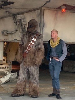 Chewbacca character and a Star Wars–themed cast member standing near the Millennium Falcon at Disneyland.