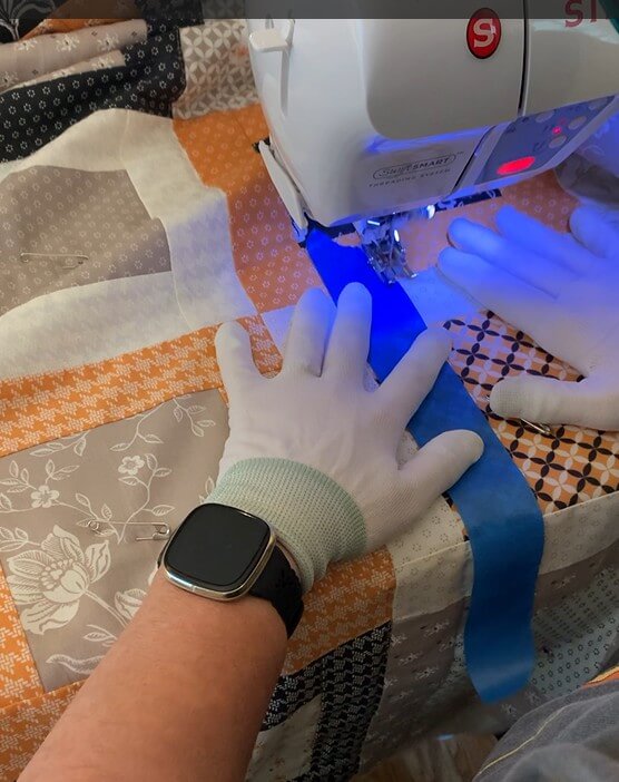 Straight-line quilting on a Fall Framed Windows quilt using painter’s tape and quilting gloves