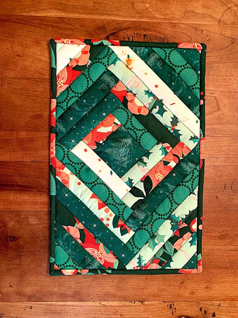 Quilted casserole hot pad quilt made from green and teal fabric scraps
