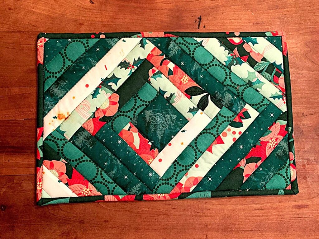Scrap quilted casserole hot pad with log cabin style piecing