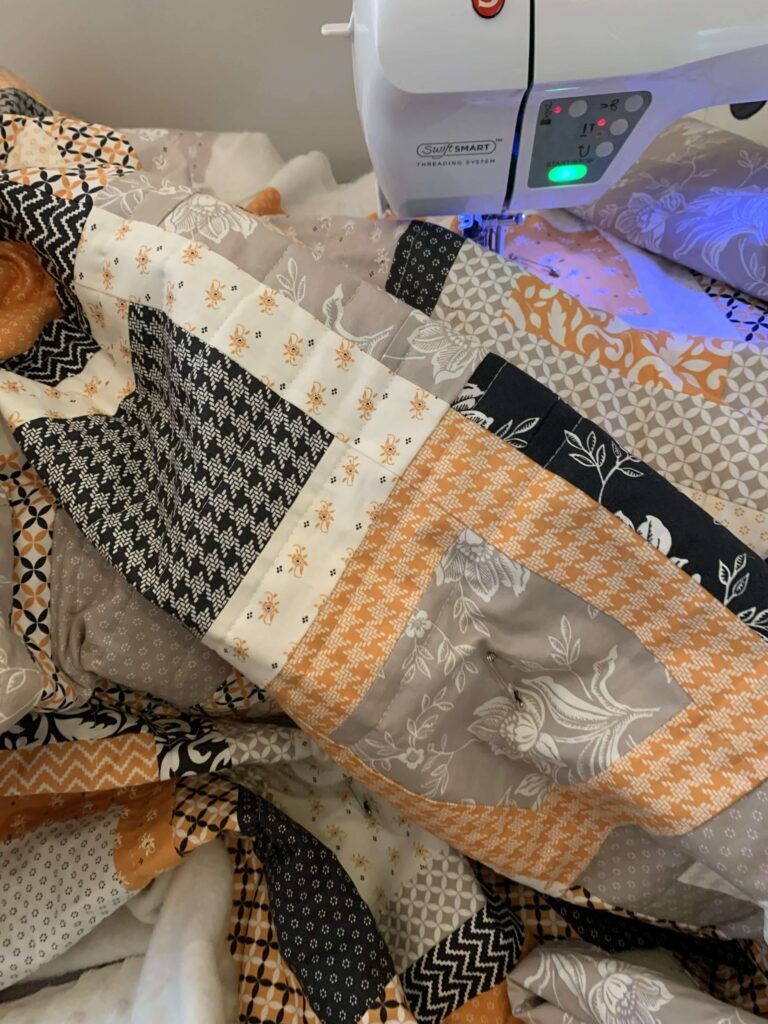 Straight-line machine quilting in progress on a Fall Framed Windows quilt