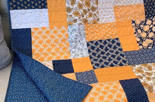 Layer cake loop quilt displayed on a sofa, showing patchwork layout