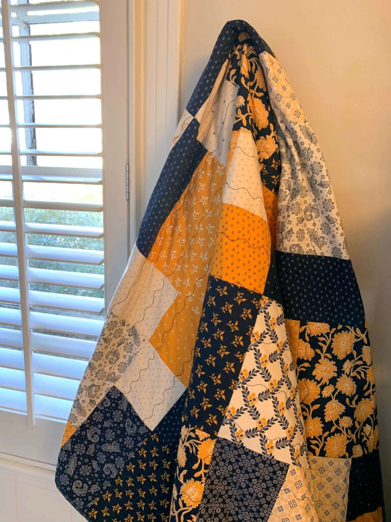 Layer cake loop quilt hanging to show drape and quilting lines