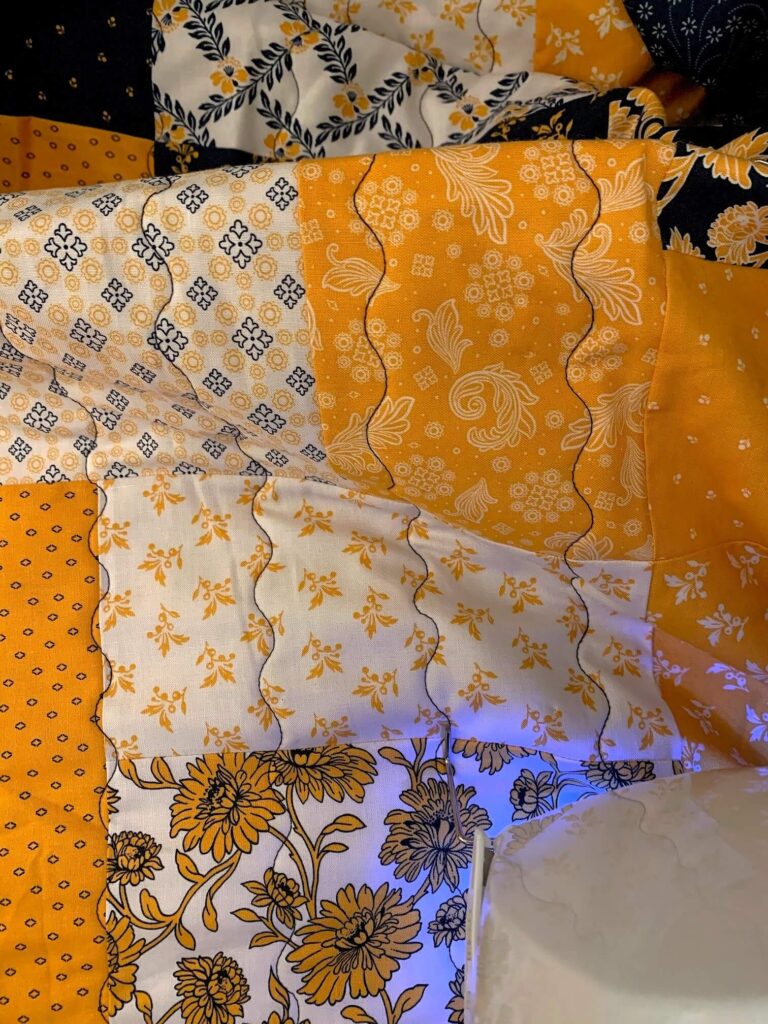 Close up view of wavy quilting on patchwork quilt