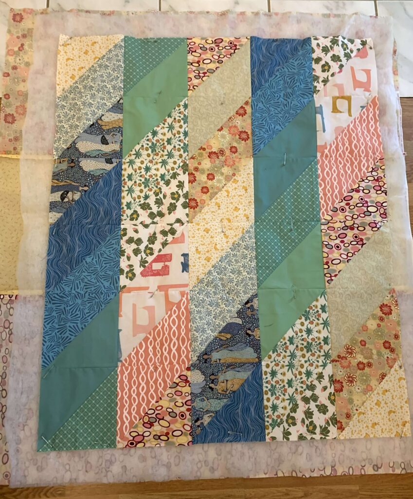 Mini quilt layered with batting and backing, ready for quilting